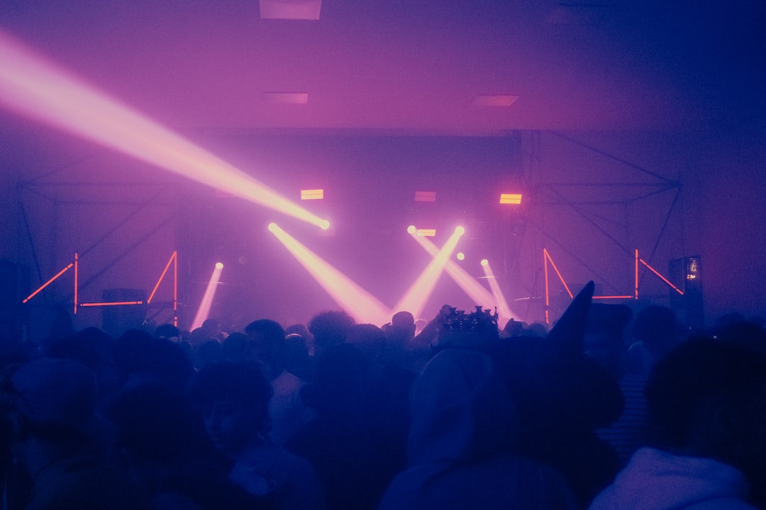 Massive illuminated concert stage with laser lights cutting through fog